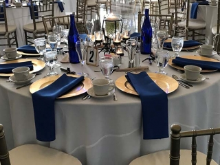 Table setting with blue napkins and gold plates